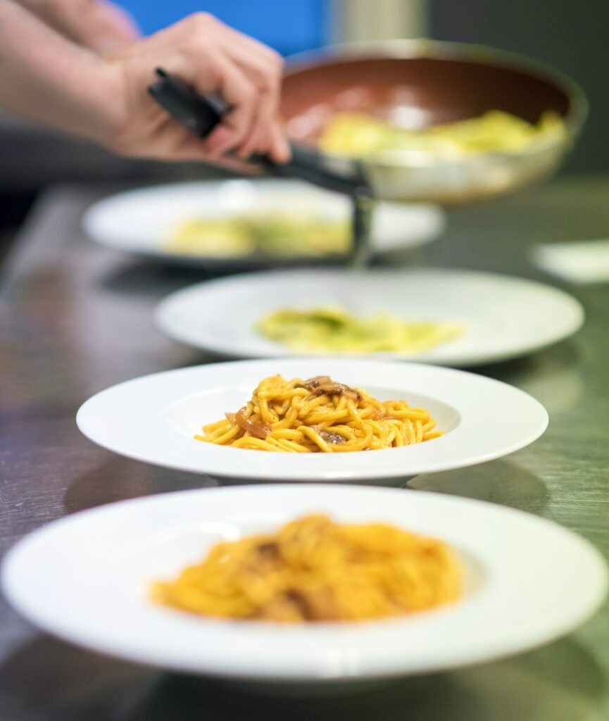 Chef serving or plating up pasta in a restaurant